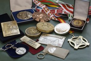 Bodegón de Medallas, Estuches, Llaveros, Fundas, Pisapapeles y Cintas.